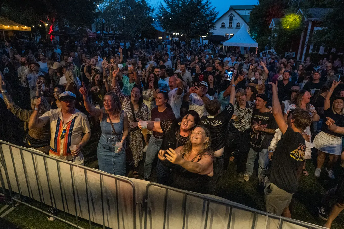 A Danger80s crowd at a live show — packed dance floor under neon stage lighting